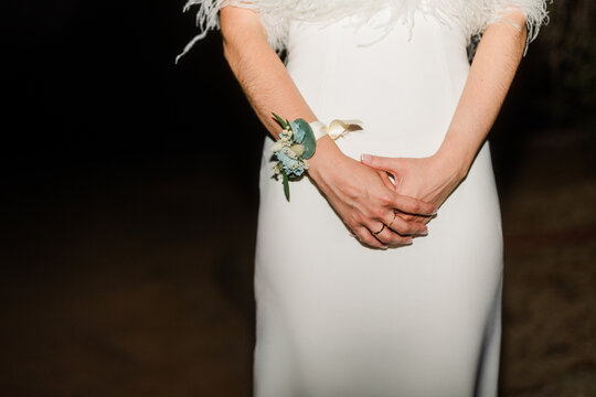 Bride in white wedding dress with floral wrist corsage