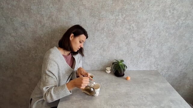 Woman prepares tea alone at home on a quiet morning
