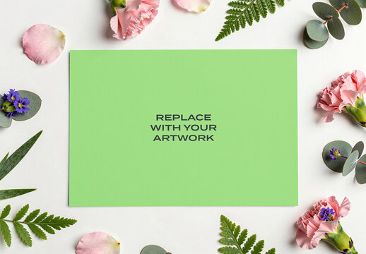 Rectangular poster mockup on a white surface surrounded by pink carnations, eucalyptus leaves, fern fronds, design, presentation, display, blank