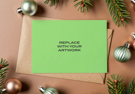 Stationery mockup with brown envelope and holiday decorations on a neutral surface, realistic card presentation featuring pine branches ornaments