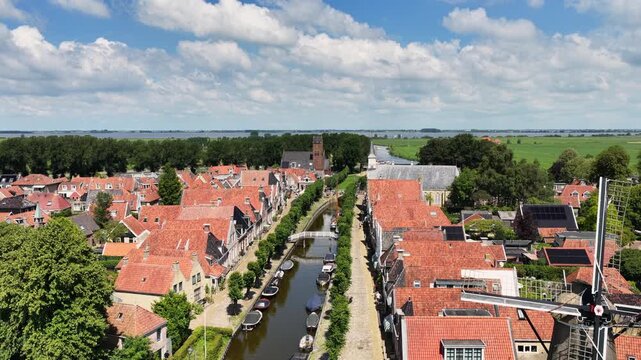 Aerial view of a historic canal town with windmill and landmarks in the Netherlands