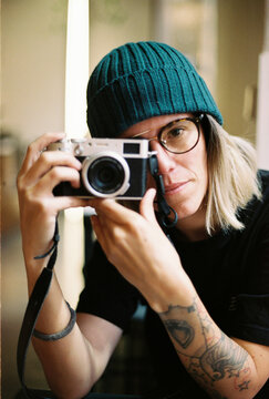 Woman in knit beanie hold film camera for portrait