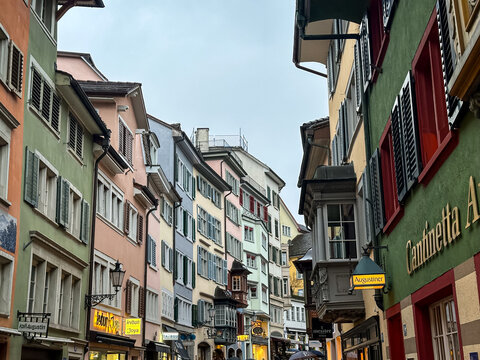 Zurich, Switzerland - March 14, 2026. Colorful Facades and Traditional Bay Windows on Augustinergasse in Zurich. A low-angle view showcasing the vibrant, multi-colored historical building facades alon