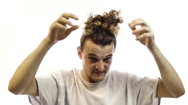Man Grooming and Combing His Hair While Looking at Camera on White Background