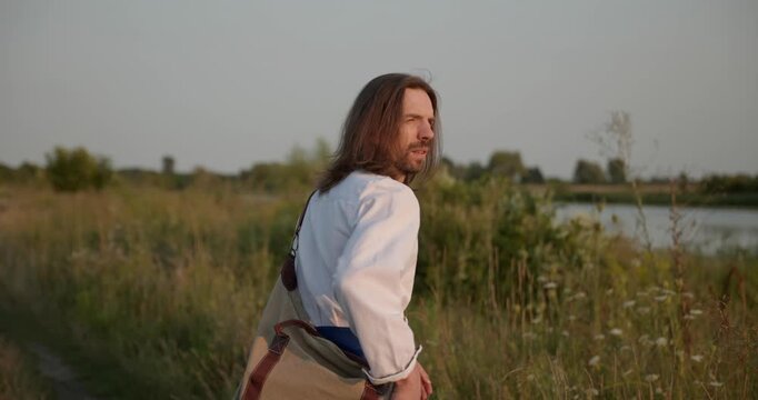 Caucasian man with long hair and Ukrainian traditional folk attire run away being chased . 4K 10-bit