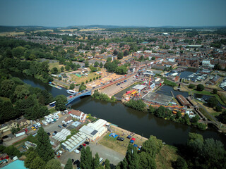 Fototapeta premium Aerial drone view of Stourport-on-Severn town centre, Worcestershire, England. Bird's eye perspective of the historic market town, streets, red brick buildings, and surrounding landscape.