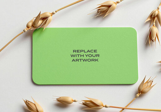 Rectangular business card mockup on a white surface with dried wheat stalks, flat lay presentation, realistic stationery branding display, template for graphic design and print