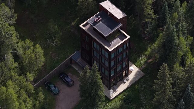 Aerial of tall mountain modern residential building in Dunton Colorado with glass windows and parking area