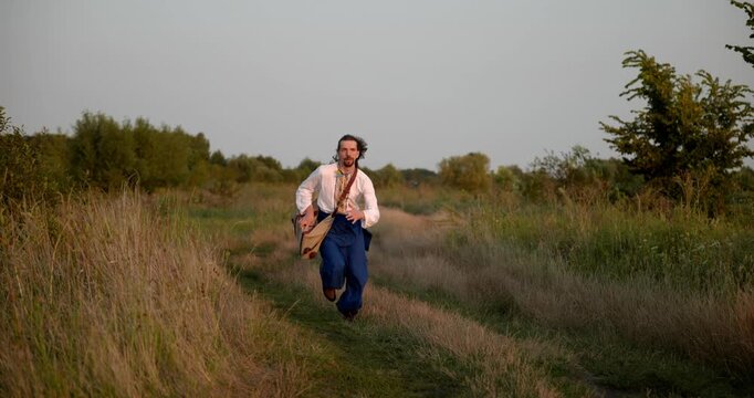 Caucasian man with long hair and Ukrainian traditional folk attire run away being chased . 4K 10-bit