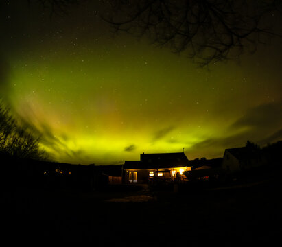 The Aurora Borealis, the northern lights, showing up above bungalow in County Donegal, Ireland