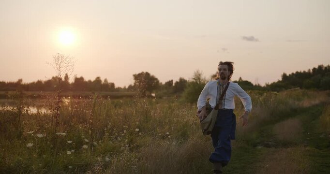 Caucasian man with long hair and Ukrainian traditional folk attire run away being chased . 4K 10-bit