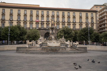 oriental fountain in piazza municipio square with historic buildings and pigeons in naples italy © Vytenis