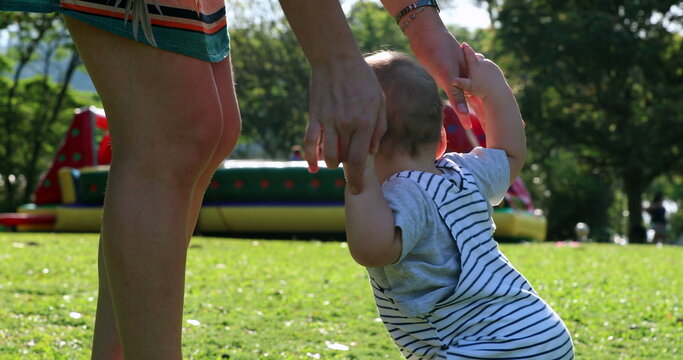 Baby toddler steps barefoot otuside in park grass