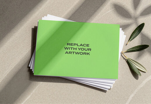 Stationery mockup with text replace your artwork on a stack of papers displayed textured surface natural light and olive branch, presentation for branding, graphic design, print, advertising