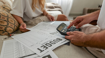 Couple reviewing budget documents and using a calculator for financial planning