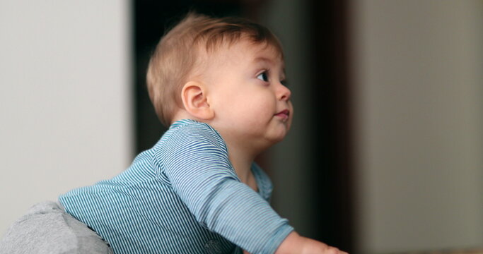 Baby holding to doorstep stair observing the world. Toddler development