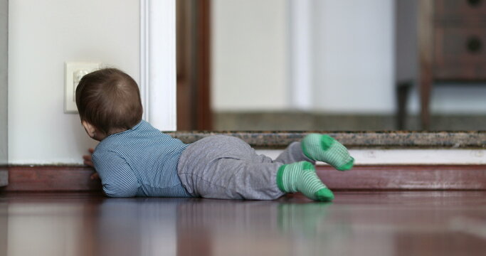Baby touching electrical power plug