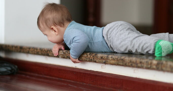 Baby infant learning to climb down step. Toddler development