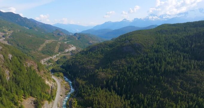 Mountains covered in forest, a river and Sea to Sky Highway between them. Canada