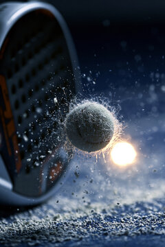 Close-up of padel racket striking ball, frozen motion, detailed texture of ball fibers and court surface, dramatic sports lighting