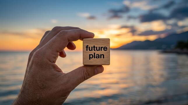 Person planning ahead at dusk near the water holding a wooden block with future plan.