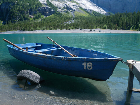Empty Blue Rowboat Floating on Turquoise Alpine Lake Water, Vacation Rental, Switzerland Tourism