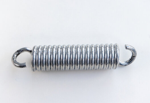 New metallic industrial coiled spring mechanism on a bright white surface