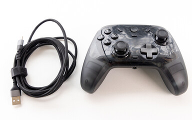 Black Transparent Game Controller and Braided USB Charging Cable on White Background © YouraPechkin