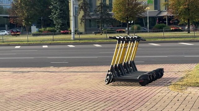 Shared electric scooters parked on a city street, representing sustainable urban mobility, micromobility, low-carbon transport, smart cities and last-mile travel.
