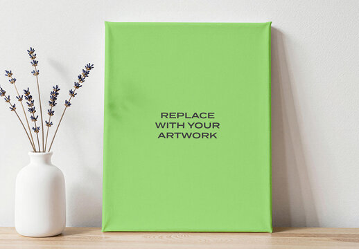 Vertical canvas print mockup displayed on a wooden surface, interior wall art presentation with white vase and dried lavender, realistic graphic design template for branding advertising display
