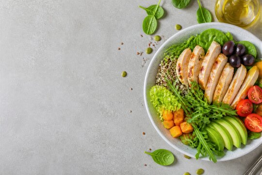 Grilled chicken bowl with avocado and vegetables on table