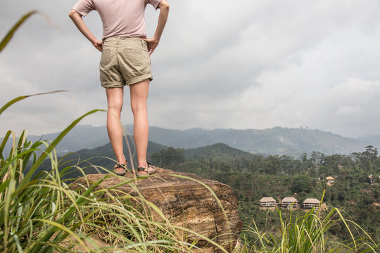 Active caucasian blonde woman enjoing fresh air and pristine nature while tracking among tea plantaitons near Ella, Sri Lanka. Bacpecking outdoors tourist adventure.