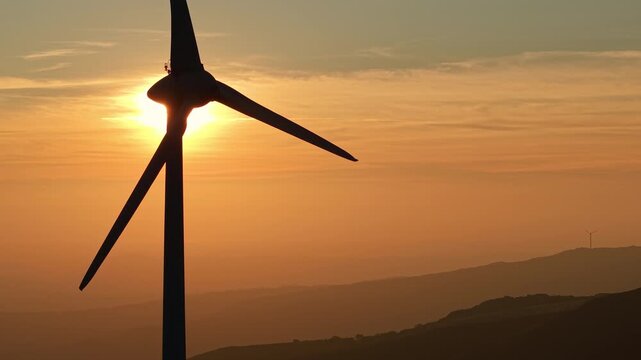  Wind turbine silhouette in glowing sunset sky