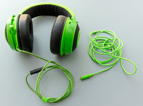 Vibrant Green Headset and Coiled Audio Cables on a Grey Surface