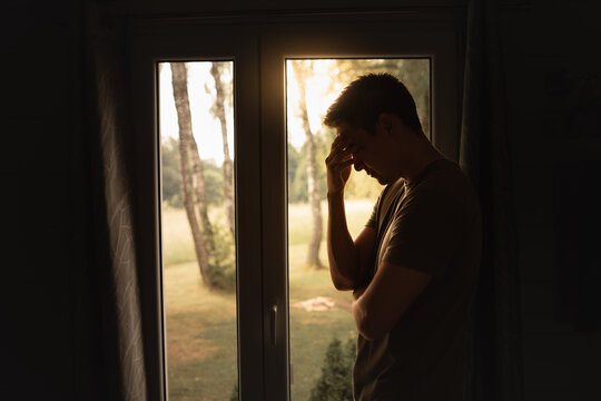 Young man feeling depressed sad in a dark room 