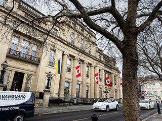 Fototapeta premium Canadian embassy building with flags and pedestrians on a London, UK street in winter