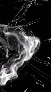 Animation grey ring of smoke over light on moving shiny black plastic