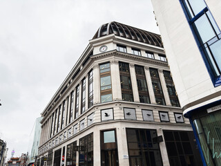 Fototapeta premium Historic department store building with clock tower and modern shops on a London, UK Panton street