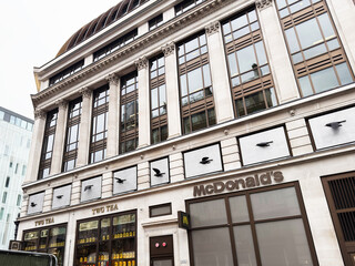Fototapeta premium McDonalds and TWG Tea storefront on a historic commercial building facade in London, UK