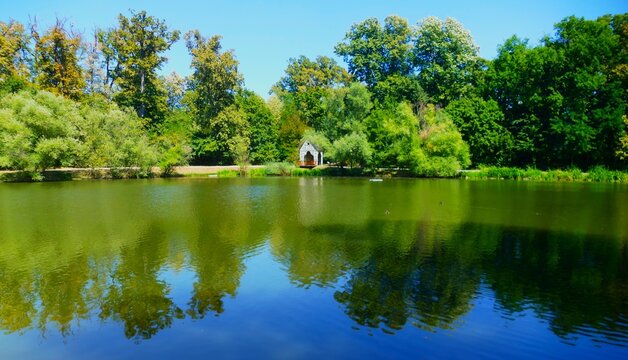 Wooden fisherman house on the peaceful lake with trees and reflection in beautiful green nature, peaceful lakes background