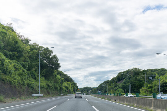 澄み渡る青空と夏雲が広がる高速道路とドライブ風景の背景素材