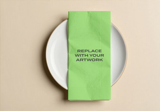 Paper napkin mockup on a white ceramic plate in an overhead view of table setting, flat lay presentation with placeholder for artwork, stationery branding template graphic design