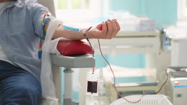 Male patient squeezing stress ball during blood donation