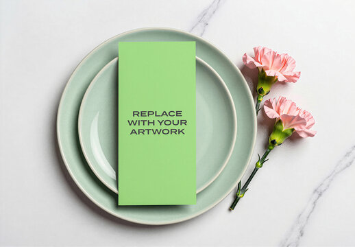 Vertical brochure mockup on stacked ceramic plates with pink carnations arranged a marble surface, flat lay overhead view, minimalist stationery branding presentation for print media