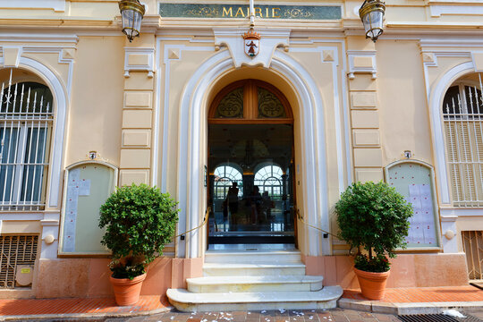 Entrance of the Town Hall of Monaco, with ornate gilded lettering, crowned coat of arms .