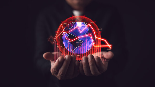 Businessman holding glowing global hologram with red downward graph. Concept of economic crisis, stock market crash, financial loss, global recession, and negative business decline.