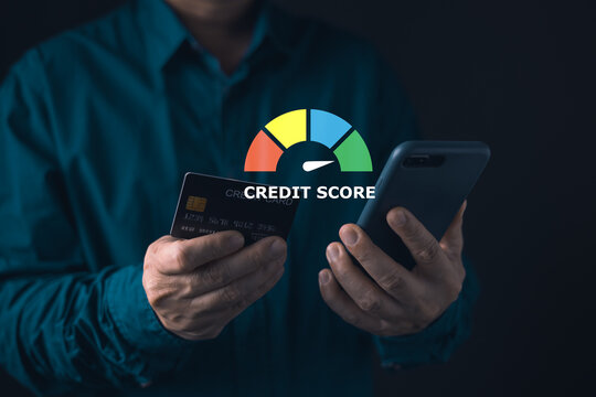 Man checking personal credit score on smartphone. Financial rating gauge graphic. Holding credit card and mobile phone. Good financial health, loan approval, and digital banking.