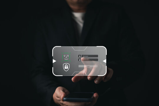 Businessman holding smartphone with facial recognition biometric login. Hologram of cyber security shield and padlock. Concept of modern data protection, secure access, and digital privacy.