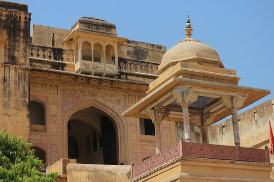 Traditional Rajput architecture with carved balconies and a domed chhatri pavilion at the historic Amber Fort in Jaipur.