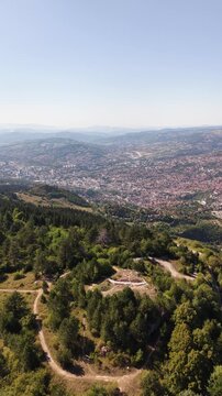 Vertical Aerial View of Drone Flyover Over Trebevic Slopes Towards Sarajevo Valley Cityscape, Bosnia and Herzegovina